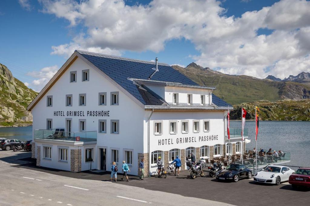 上瓦尔德Hotel Grimsel Passhöhe的水体旁的白色大建筑