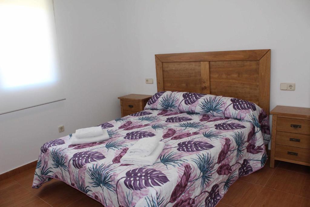 奥萨德蒙铁尔Casa Rural La Sureña 2的一间卧室配有一张床和一个木制床头板
