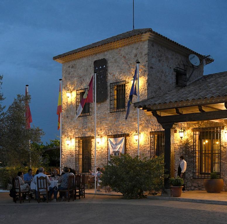 瓦拉雷伊Hotel Rural La Moragona的一群人坐在建筑物外面,挂着旗帜