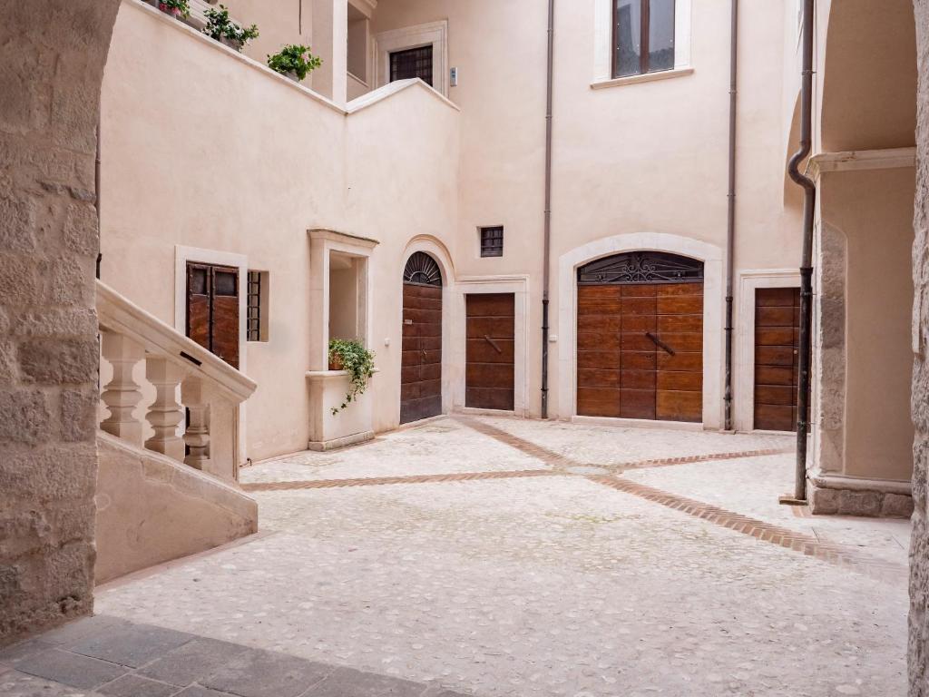 拉奎拉Palazzo dei Pavoni, Relais di Charme的大楼内带两个车库门的小巷