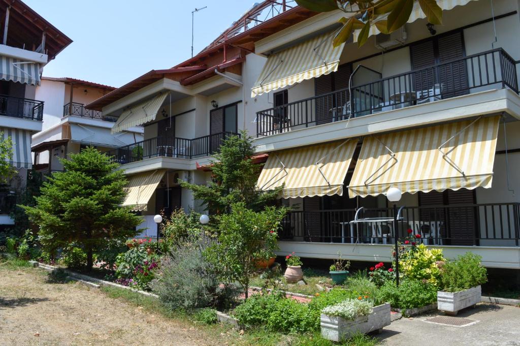 帕拉塔蒙Manos Kritikakis Apartments的公寓大楼设有阳台,种植了树木和植物