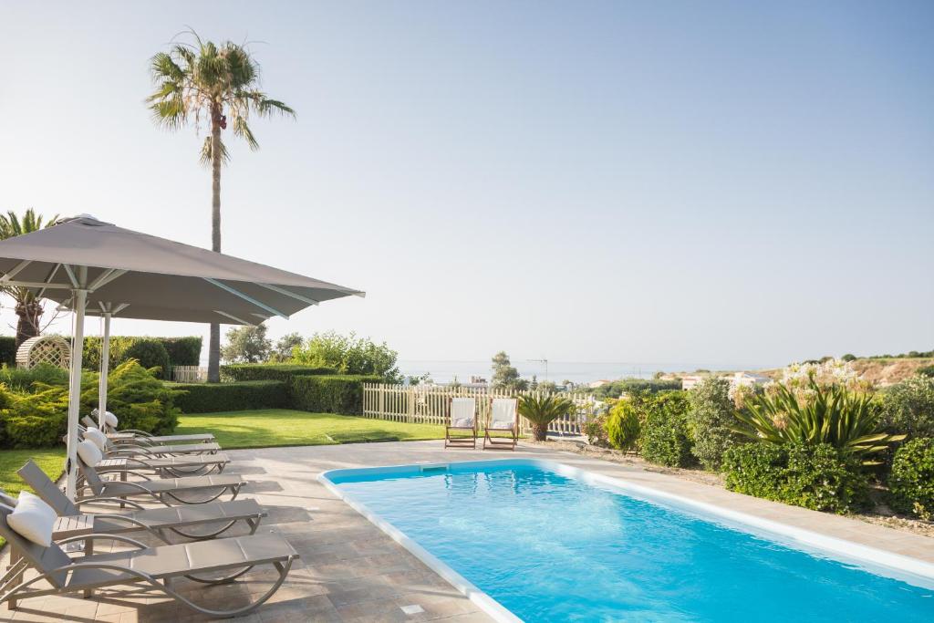 斯法卡基Malena Villa, beach retreat, By ThinkVilla的一个带躺椅和遮阳伞的游泳池