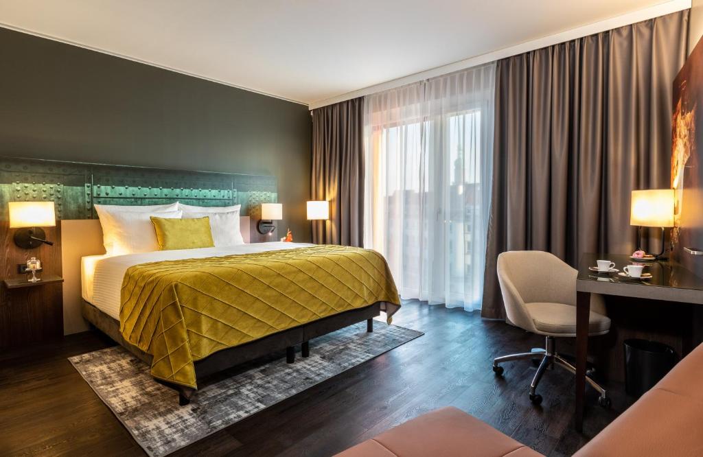 多特蒙德Leonardo Hotel Dortmund的配有一张床和一张书桌的酒店客房