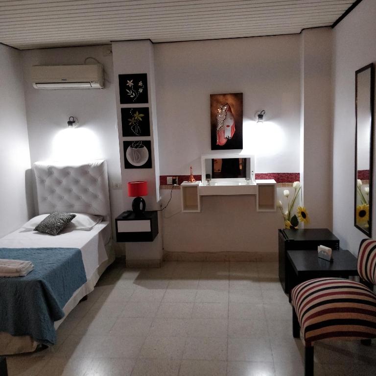 圣萨尔瓦多德朱Rosa Ramona Rooms的一间卧室配有一张床和一张书桌