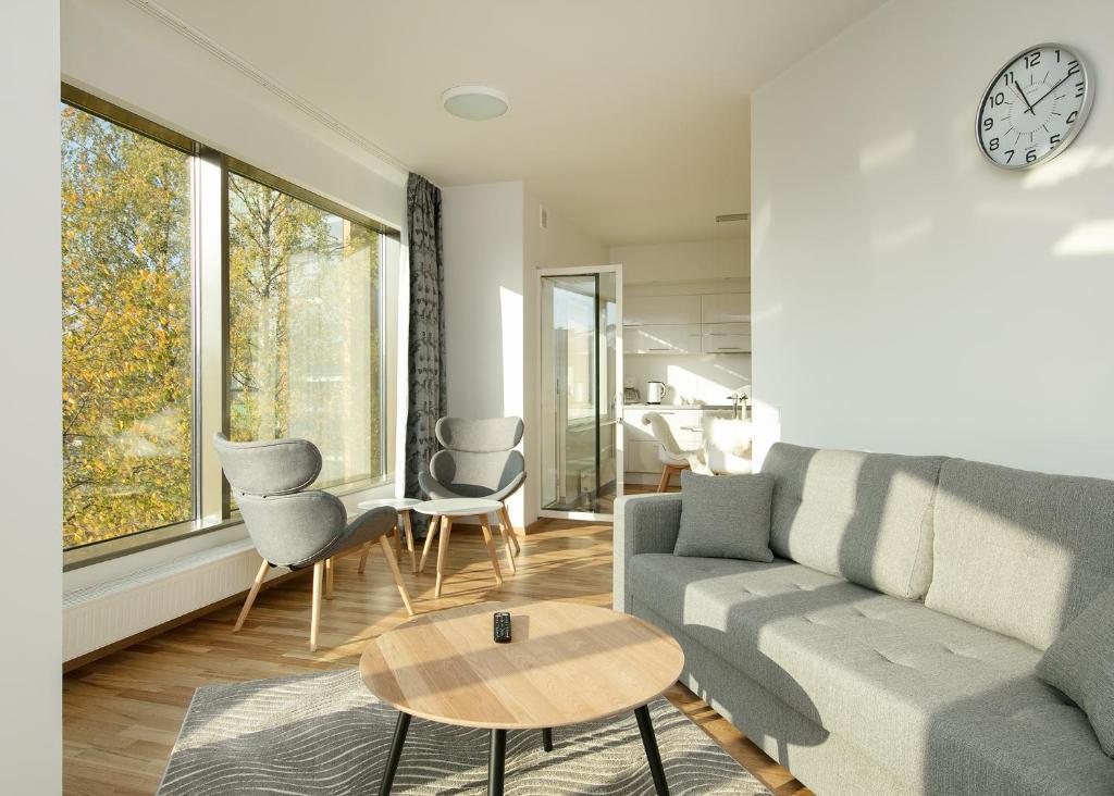 塔林Cozy Lootsi Residence with Sauna and Balcony - Tallinn city centre的带沙发、椅子和时钟的客厅