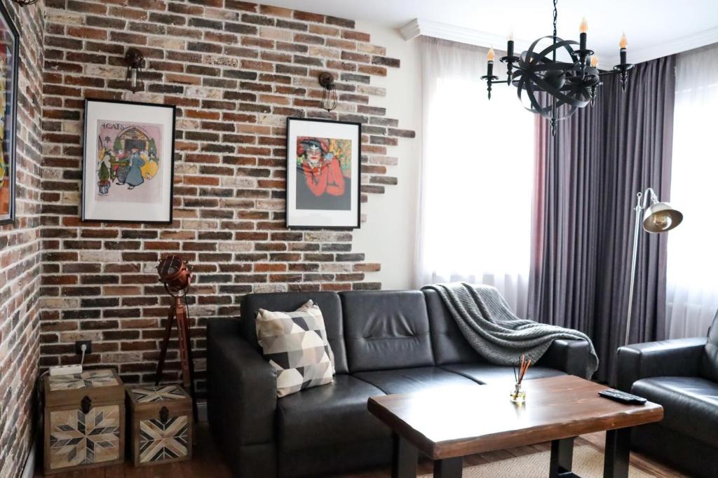 大特尔诺沃Tsarevets Apartament-Veliko Tarnovo的一间带砖墙和沙发的客厅