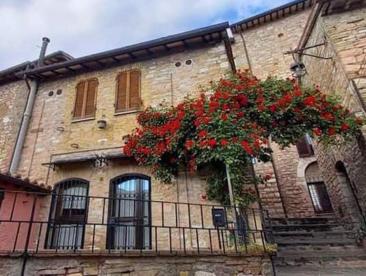 阿西西CASETTA delle ROSE的一座建筑,阳台上装有红色的鲜花