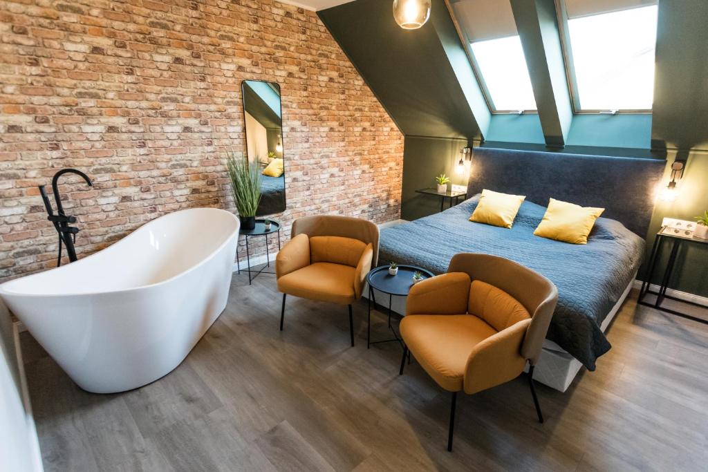 帕波Deluxe Thermal Resort的一间卧室配有一张床和浴缸