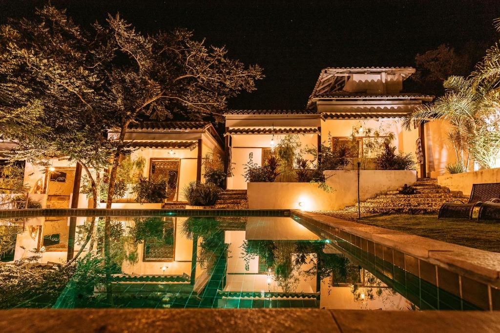 戈亚斯州上帕莱索Pousada Casa de Shiva的一座晚上设有游泳池的房子