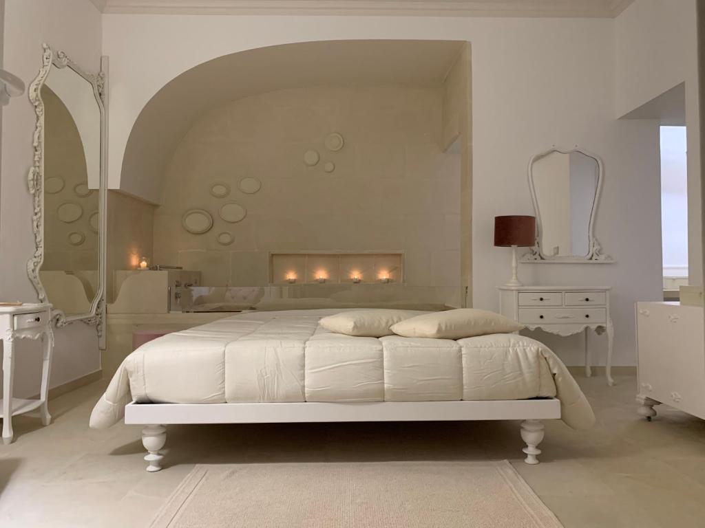 乌真托Sea Suites的白色卧室设有白色的床和壁炉