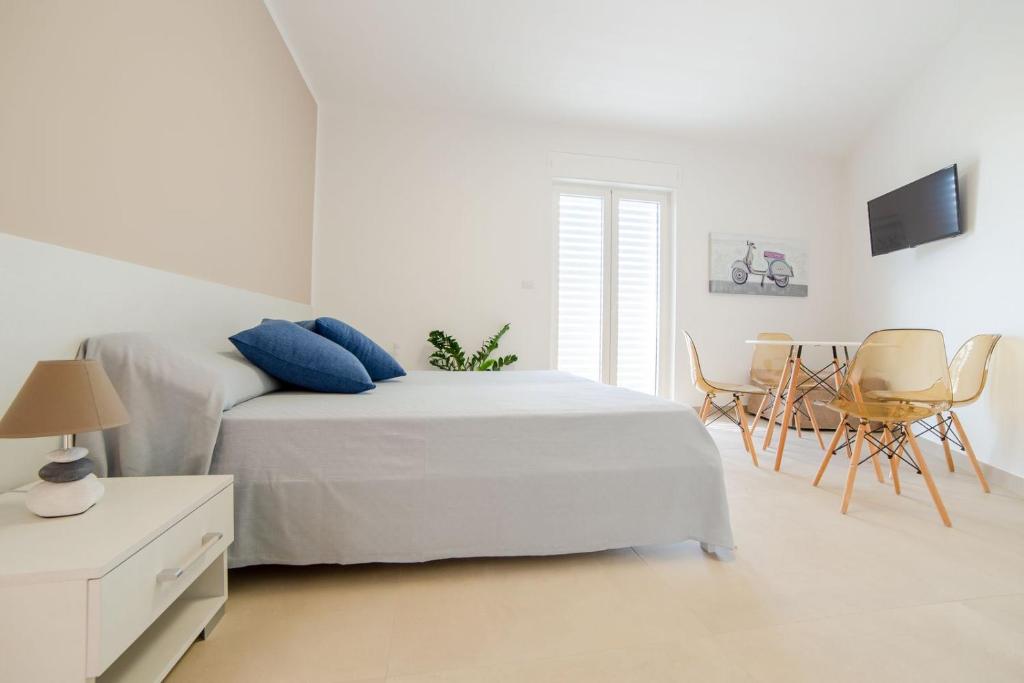 托雷圣乔万尼乌Case Vacanza Apollo的白色卧室配有床和桌椅
