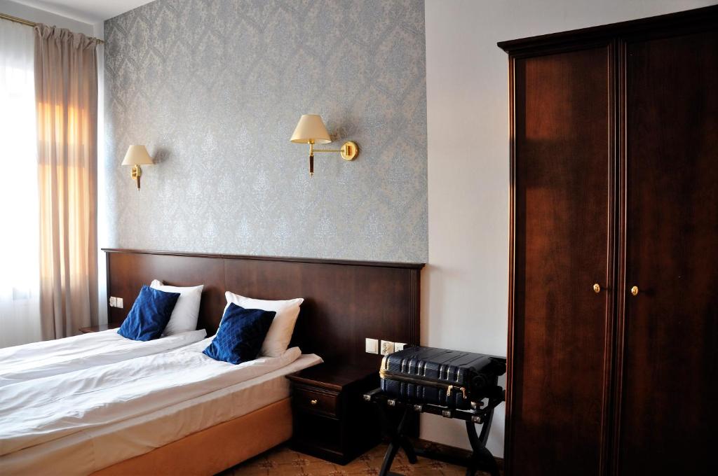卢布林Prudentia Residence Qulturalna的配有蓝色枕头的床的酒店客房