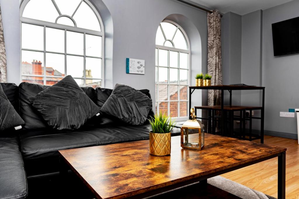 雷克瑟姆The Glyndwr - Berwyn House的客厅配有黑色沙发和木桌