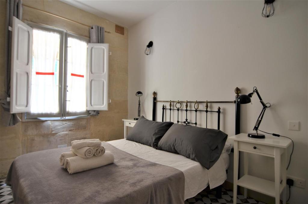 科斯皮夸Città Cospicua suites的一间卧室配有一张床,床上有毛巾