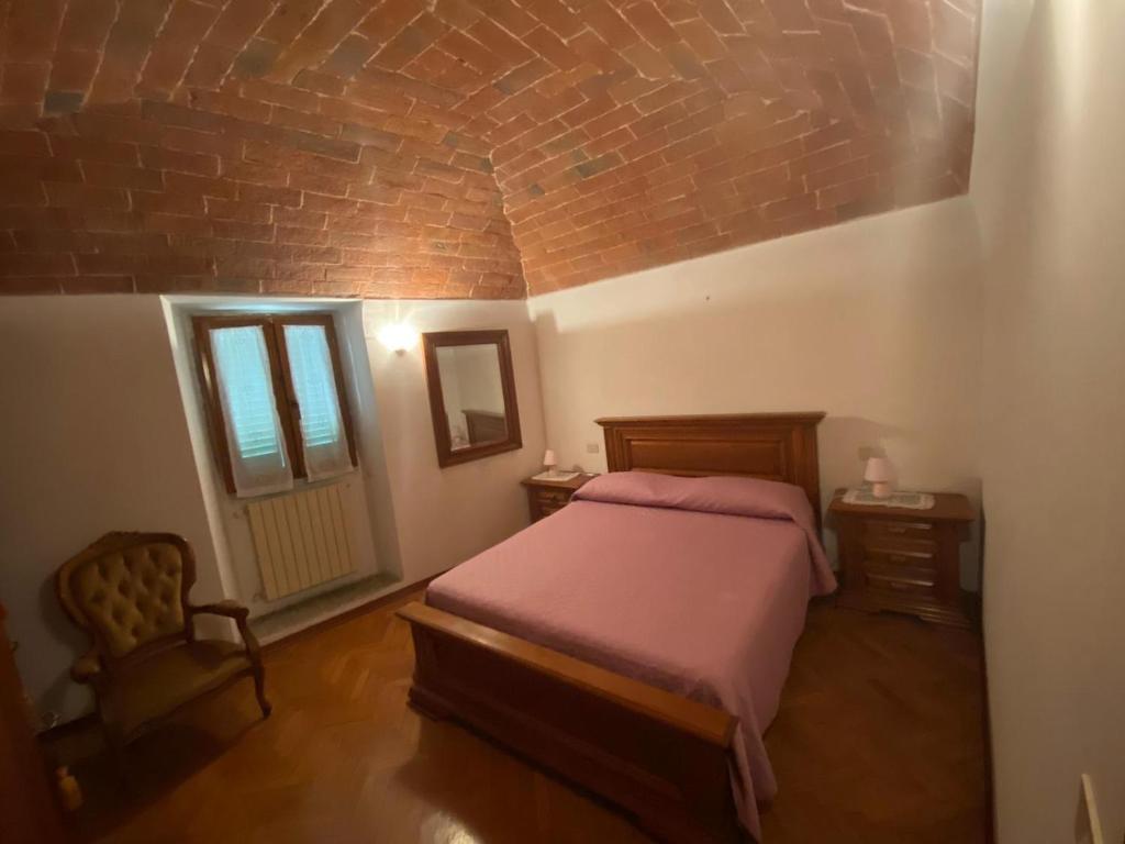 拉泰里纳Lo Sdrucciolo的一间卧室设有一张床和砖墙