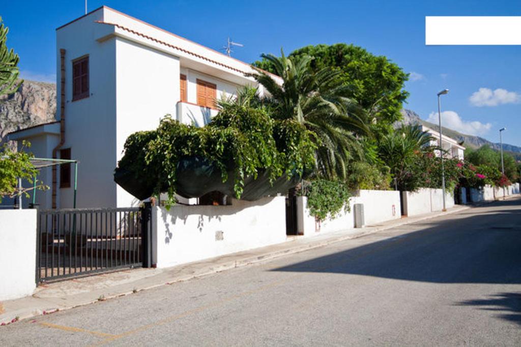 圣维托罗卡波Villetta a 10 minuti, a piedi, dalla spiaggia的一条有白色建筑和棕榈树的街道