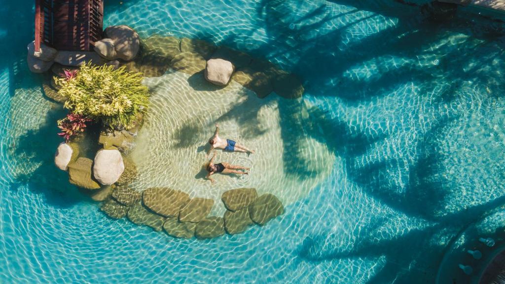 利比里亚Borinquen Thermal Resort的水中一个岛上的两个人的头顶景色