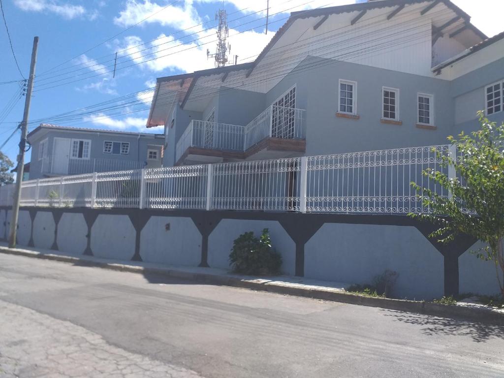 坎波斯杜若尔当Vilarejo da Esperanza的白色的建筑,在街道旁设有白色的围栏