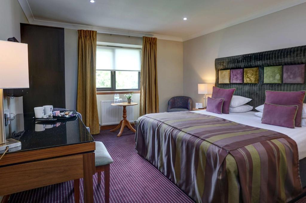 WhitburnBest Western The Hilcroft Hotel West Lothian的酒店客房设有一张大床和一张书桌。
