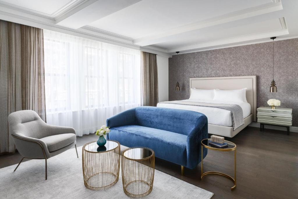 纽约The Wallace Hotel的酒店客房,配有床和蓝色的沙发