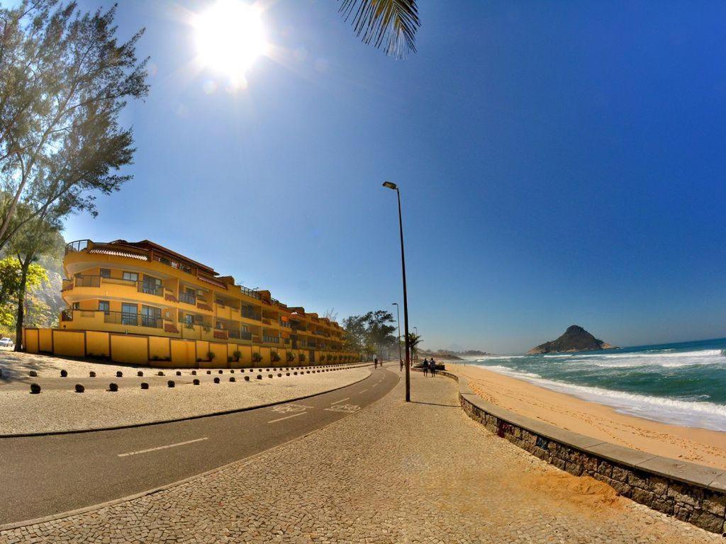 里约热内卢Apê Namastê的海滩上拥有一座建筑,有路灯和海洋
