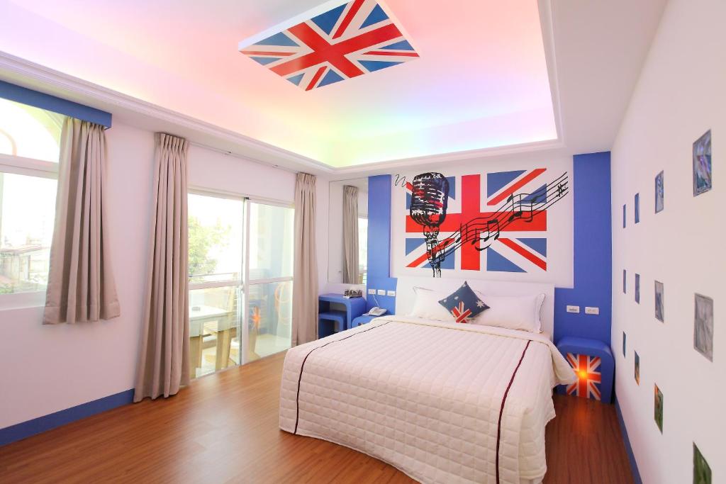 恒春古城爱丁堡十六民宿的卧室配有一张床,墙上挂着旗帜