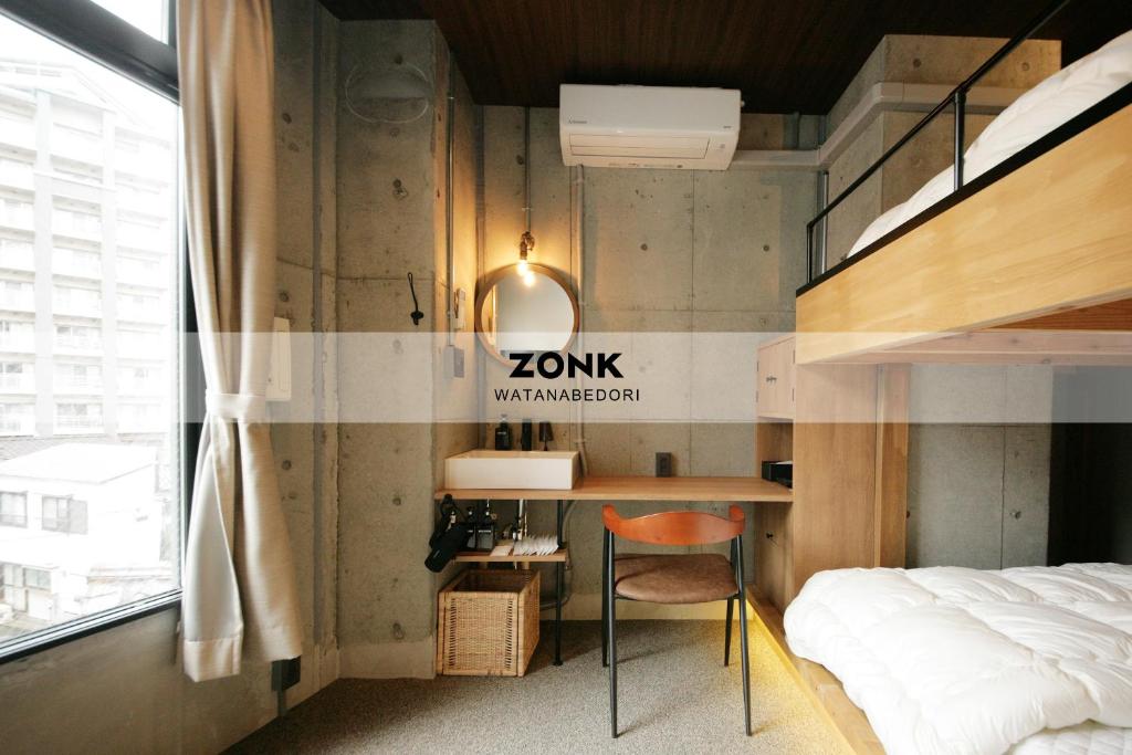 福冈ZONK HOTEL Tenjin-Watanabedori的一间卧室配有一张床和一张书桌