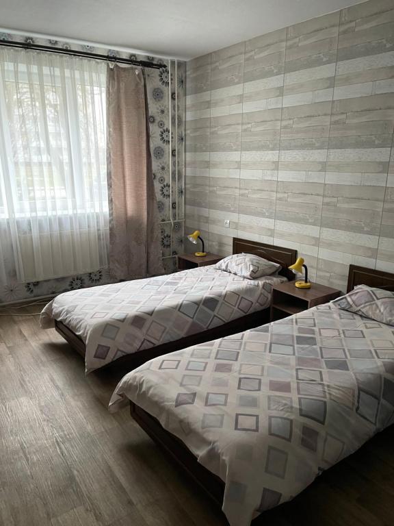 文茨皮尔斯Strādnieku viesnīca的一间卧室设有两张床和窗户。