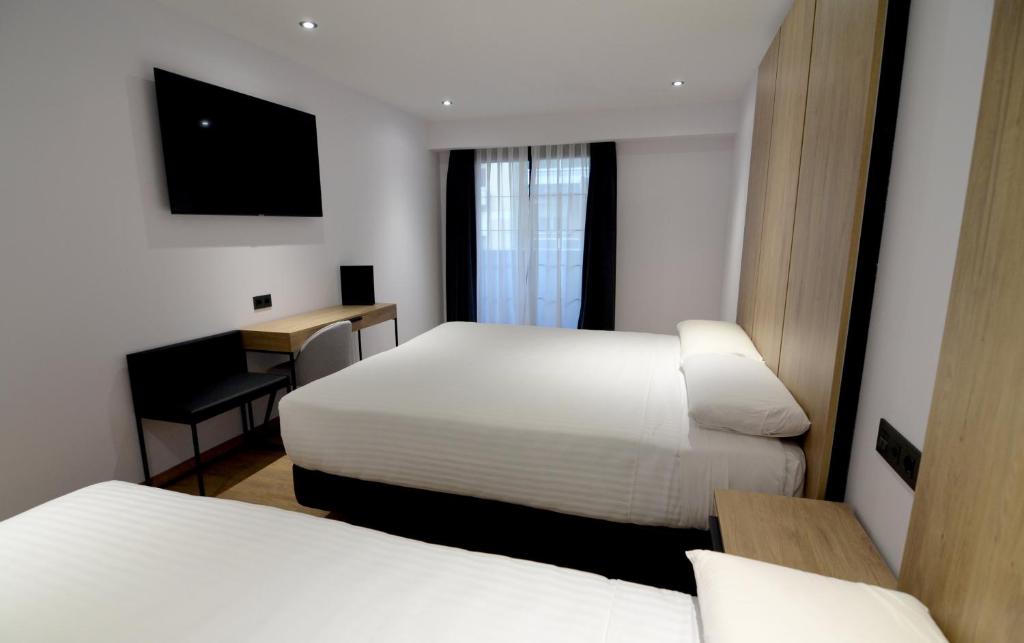 马德里UVE Marcenado的酒店客房配有两张床和一张书桌
