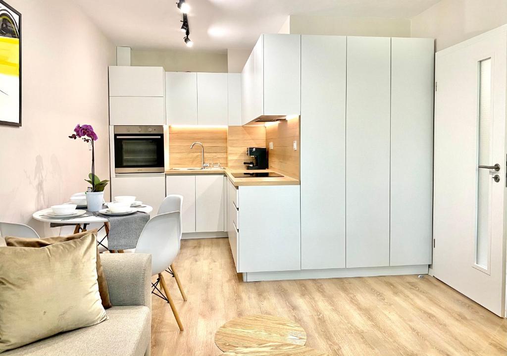 旧扎戈拉City Centre Bright & Cozy Apartment for 4 persons的厨房以及带白色橱柜和桌子的用餐室。
