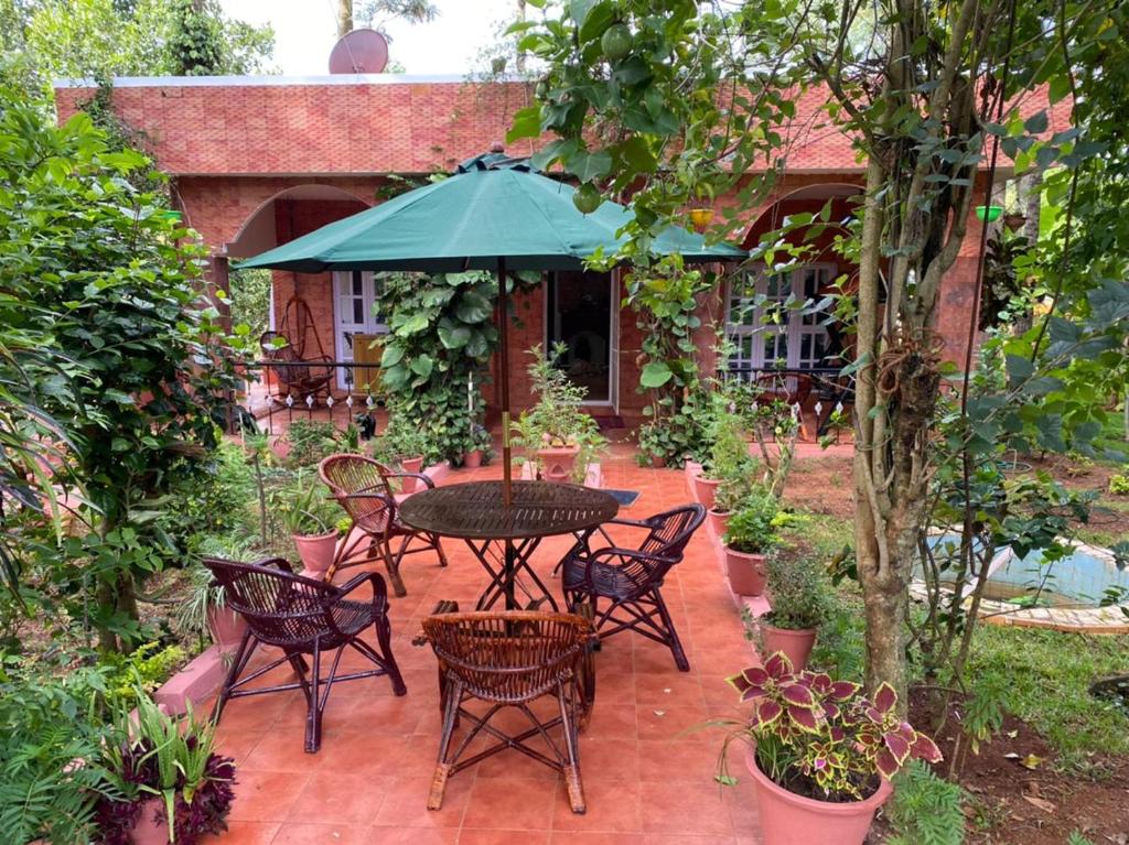 耶拉吉里Yelagiri Villa的庭院配有桌椅和遮阳伞。