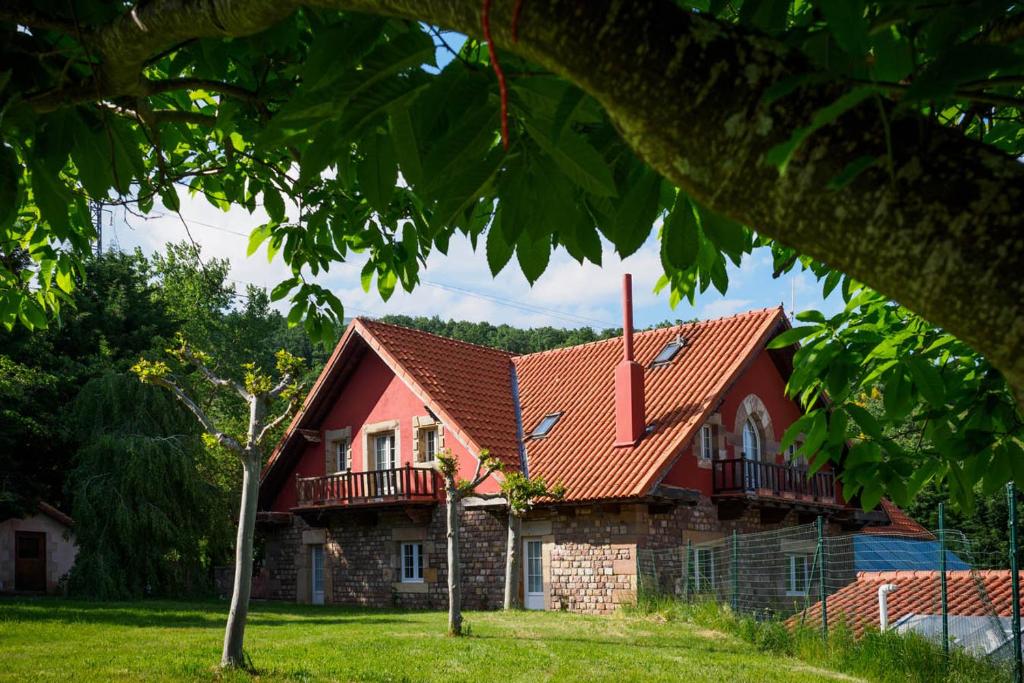 Entrambasaguas普恩特罗马诺乡村民宿的一座红色屋顶的房子和一个院子