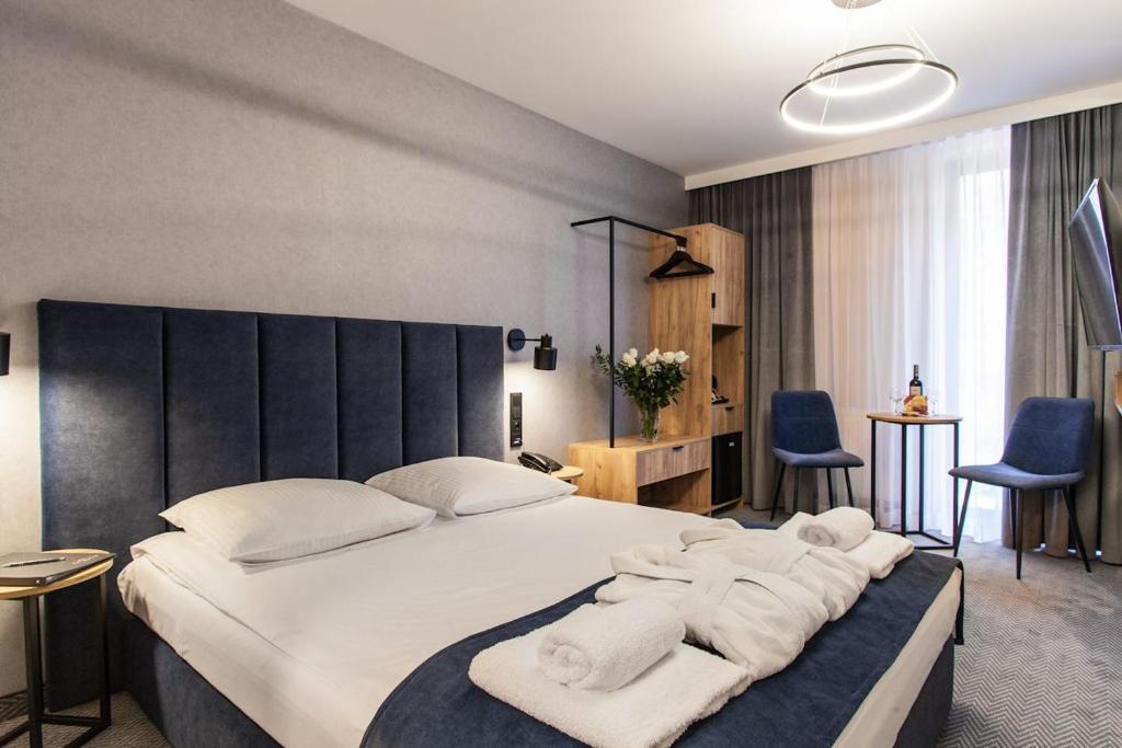 克拉科夫亚历山大酒店的一间卧室配有一张大床和毛巾