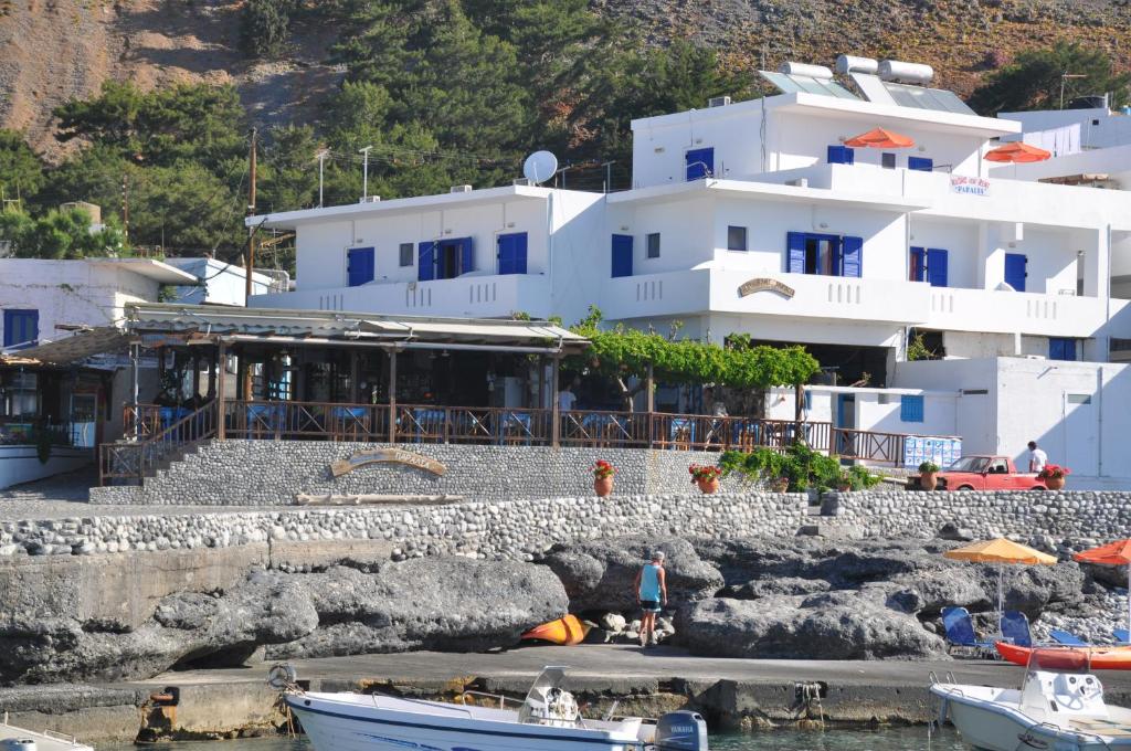 阿吉亚努美利Paralia guest house的一座白色的大建筑,水中有船