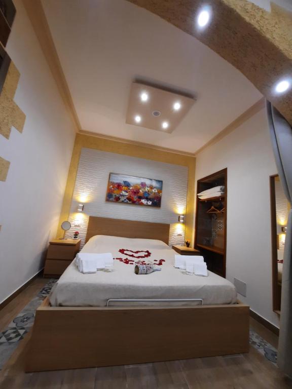 巴勒莫Il Sole della Guilla的卧室配有一张床,墙上挂有绘画作品