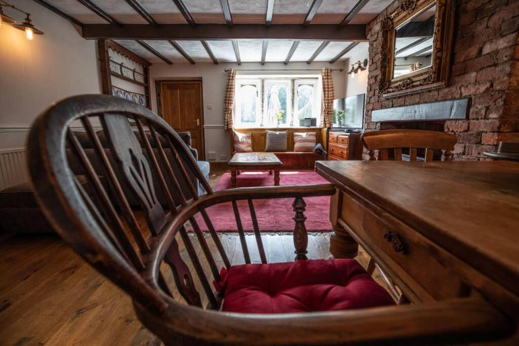 哈德斯菲尔德Clay Well Cottage的客厅配有木桌和椅子