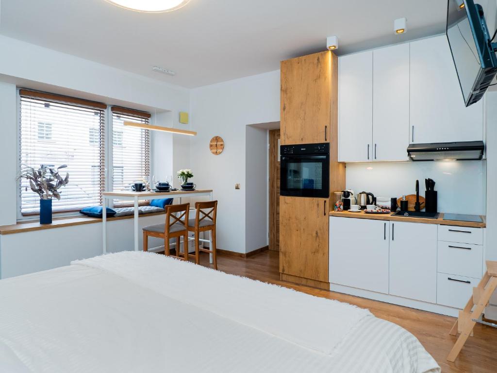 琴斯托霍瓦Apartament DeLux Aleja NMP 8 - Free parking的一间卧室配有一张床,厨房配有白色橱柜