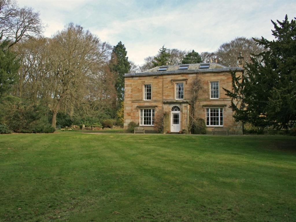 LanchesterBurnhopeside Hall的一个大砖房,有大草地庭院