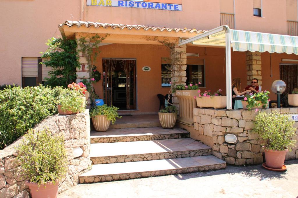 帕拉迪索海岸Hotel Mediterraneo的植物盆栽建筑的入口