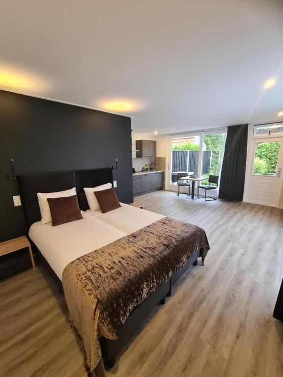 弗利辛恩Tip Top Studio Vlissingen的一间卧室设有一张大床和黑色墙壁