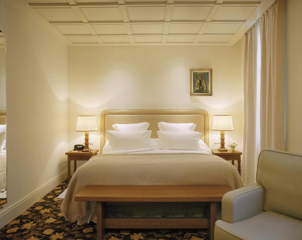 巴黎Château Voltaire的一间卧室配有一张带两盏灯和一把椅子的床。