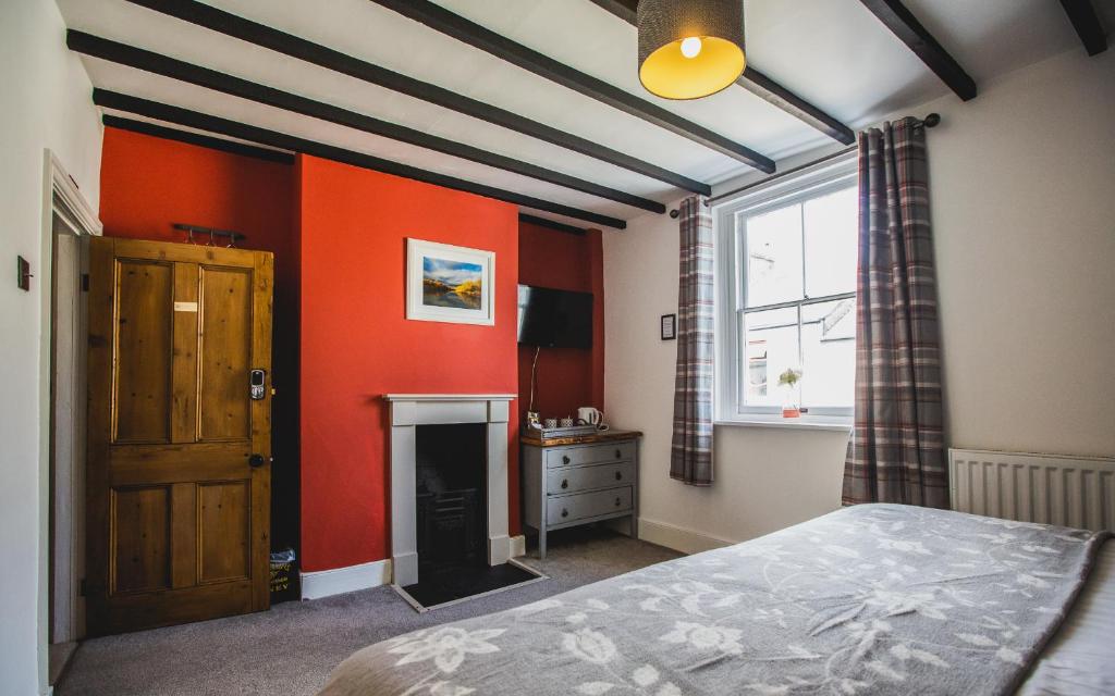 切普斯托No8 Chepstow的一间卧室拥有橙色的墙壁、一张床和窗户