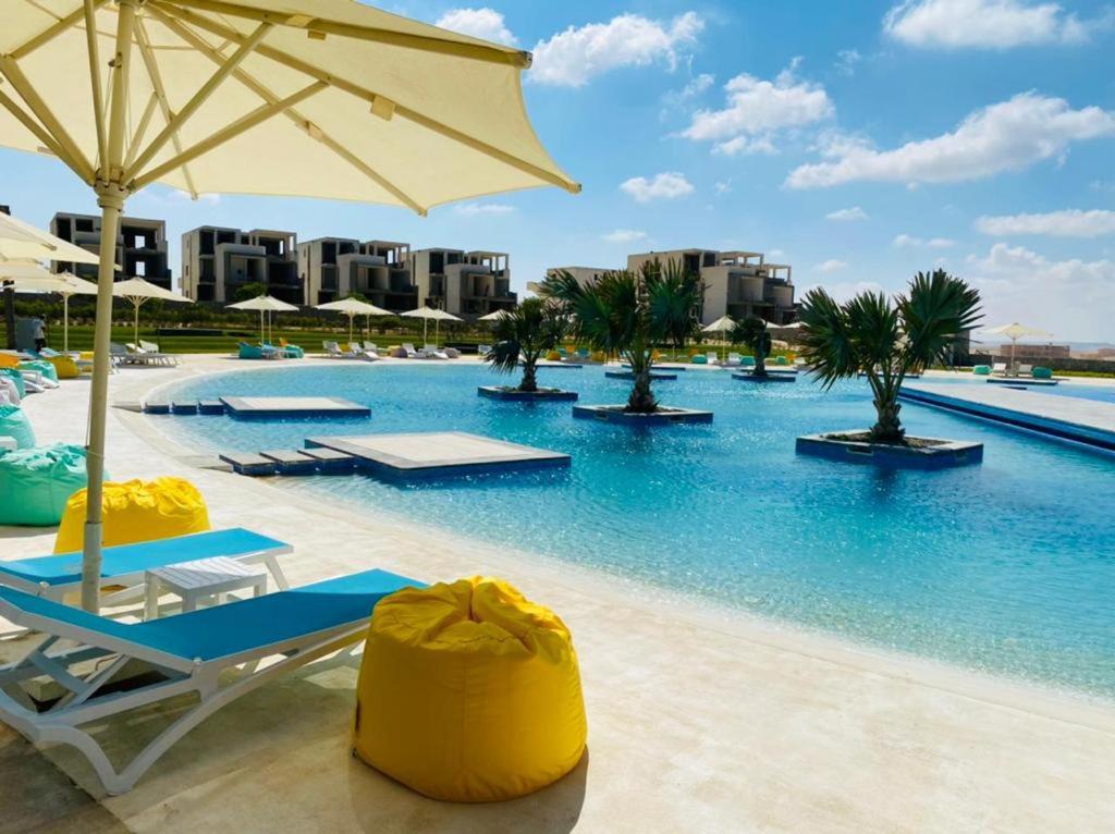 马特鲁港Fouka bay luxurious chalet的一个带躺椅和遮阳伞的游泳池