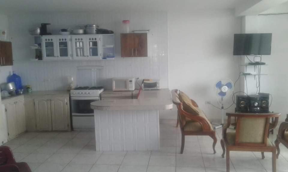 阿塔卡梅斯Casa blanca Atacames的厨房配有白色橱柜和桌椅