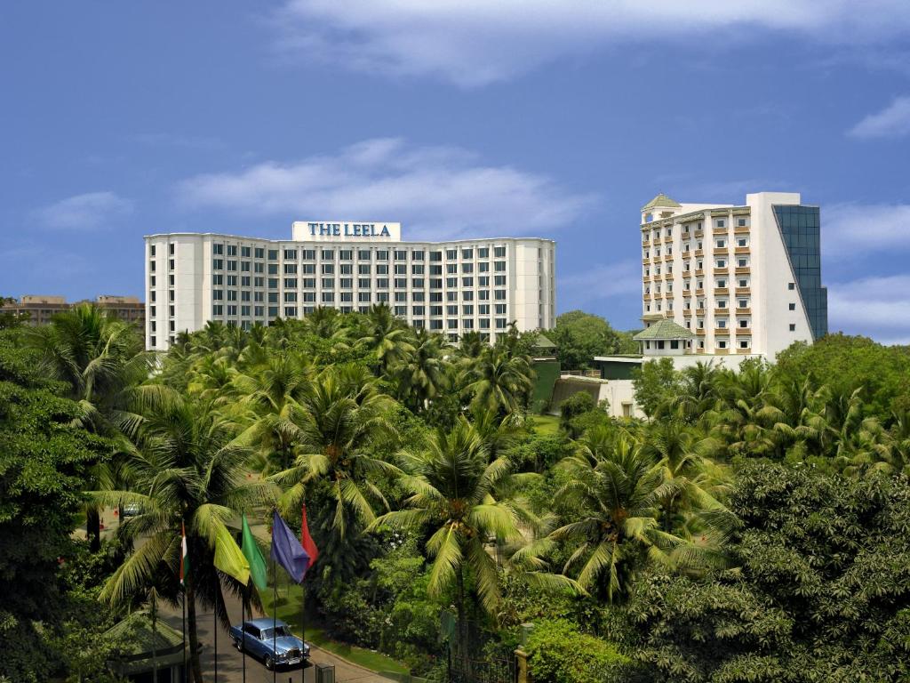 孟买The Leela Mumbai的一座楼前有棕榈树的酒店