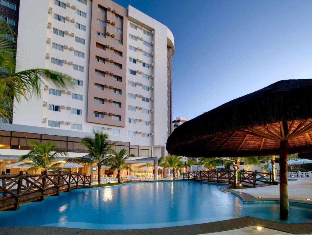 卡达斯诺瓦斯LE JARDIN Suites的一座带游泳池和大型建筑的酒店