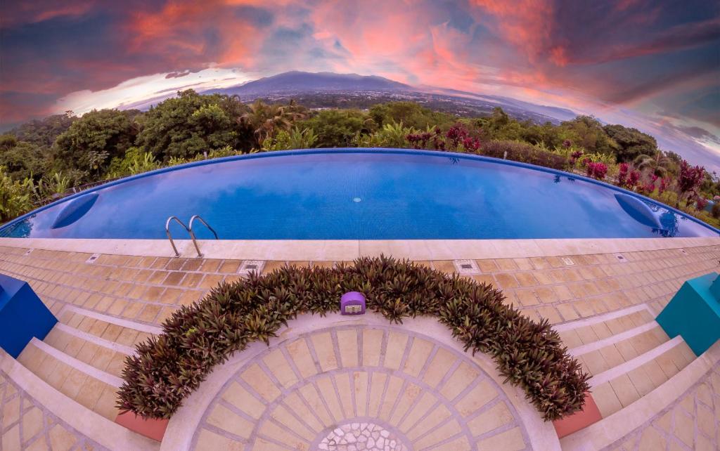 阿拉胡埃拉香达利度假酒店&Spa的一座带楼梯和天空的建筑的画