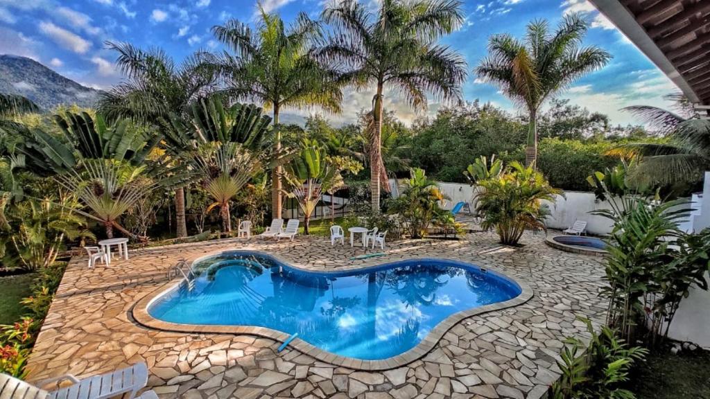 帕拉蒂加巴库阿拉海滩度假酒店的棕榈树庭院内的游泳池