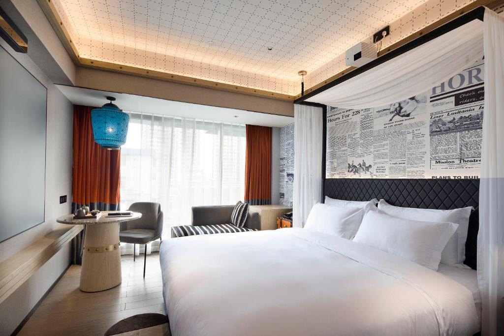 广州广州塔骑士物语酒店-Arthur Hotel Canton Tower Guangzhou的酒店客房设有一张大床和一张桌子。