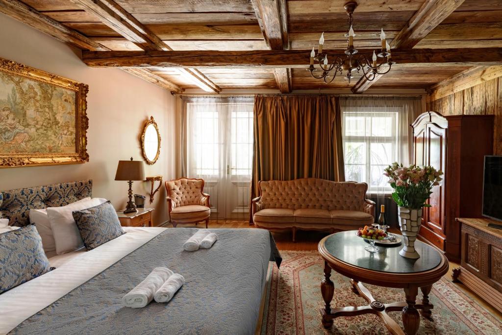 库尔迪加Boutique Hotel Virkas muiža的一间卧室设有一张床和一间客厅。